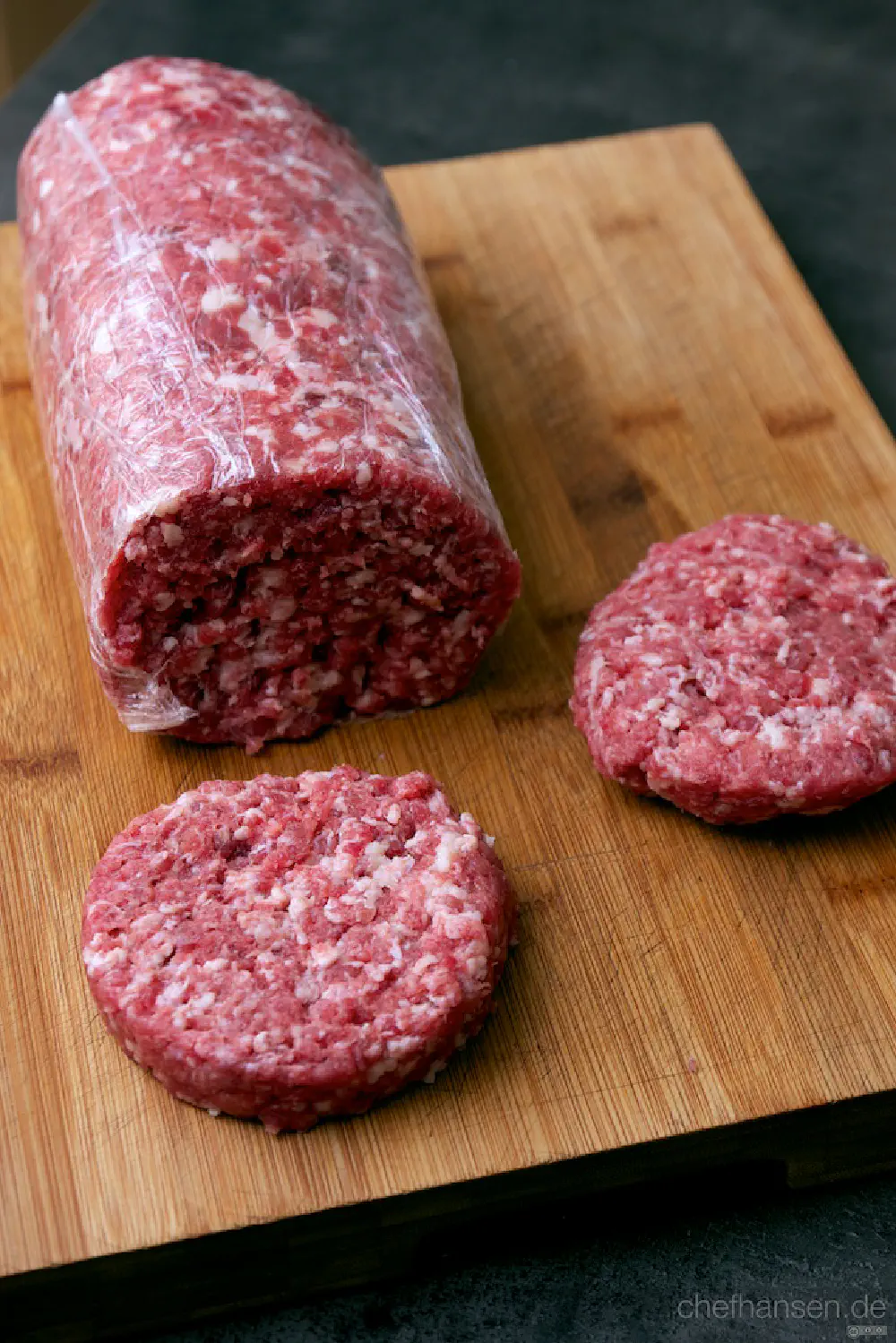 Rolle mit frisch gewolftem Hackfleisch und zwei abgeschittenen Burger Patties