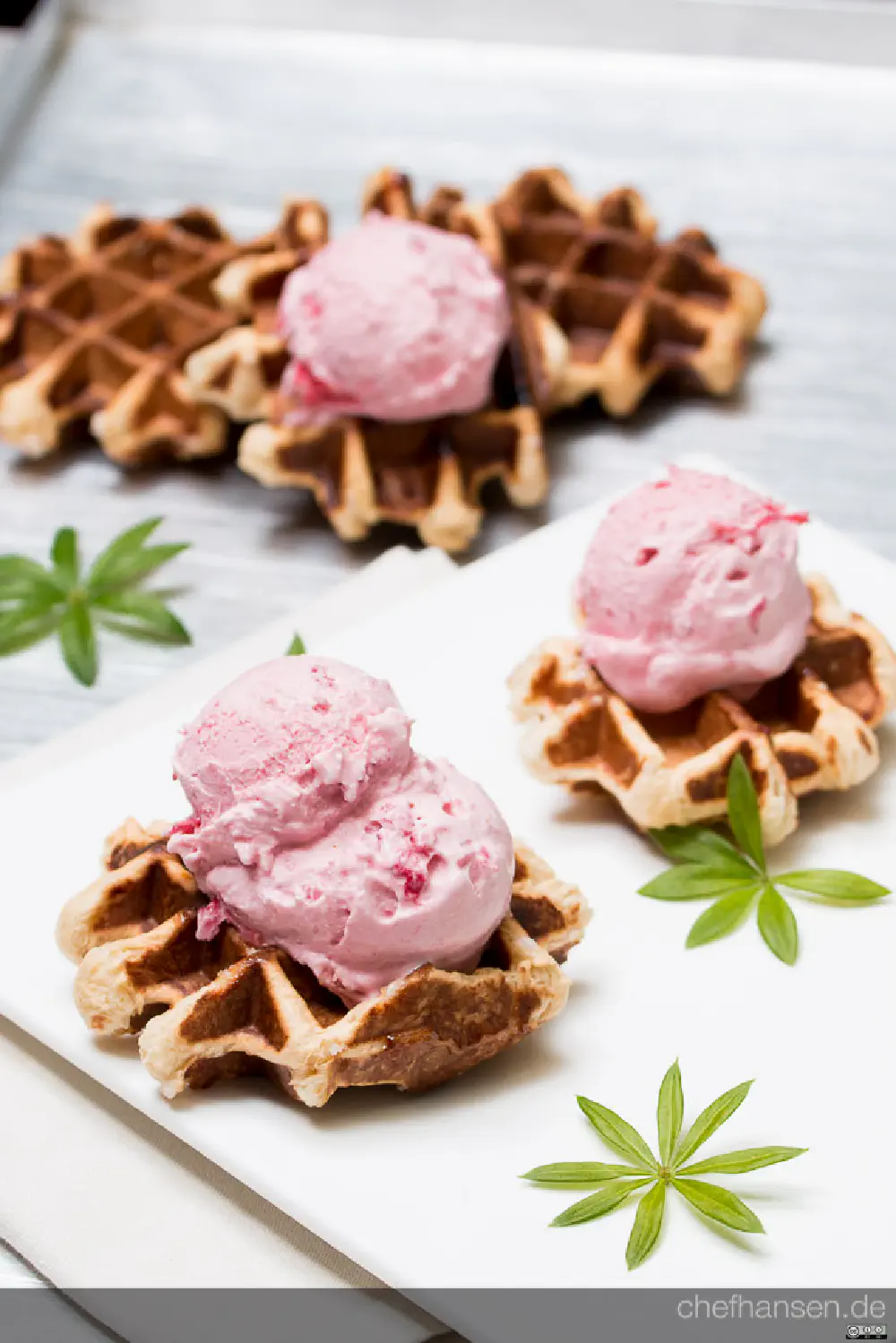 Selbstgemachtes Erdbeereis mit den besten Erdbeeren der Welt. Abgeschmeckt mit einem Schlückchen Ingwerschnaps und dicken belgischen Waffeln serviert.